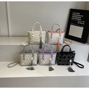 Detail view of mini bucket bags featuring woven texture and long decorative tassels