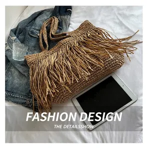 Détail d'un cabas en paille tressée avec de longues franges au style bohème plage