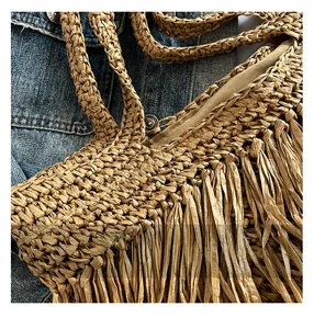 Détail de sac cabas en paille tissé à la main avec de longues franges et doublure