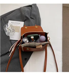 Interior storage space of retro leather shoulder bag with daily essentials and smartphone