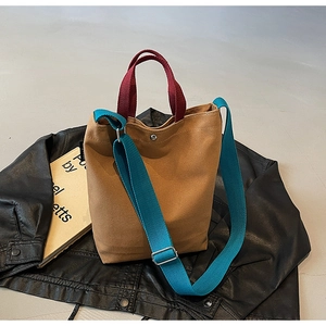 Détail du sac seau en toile color-block avec bandoulière contrastée et bouton-pression métal