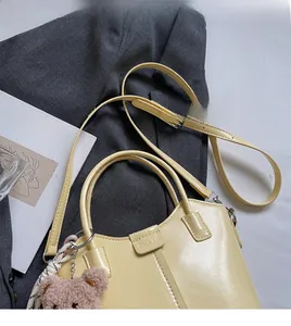 Detail of yellow bucket bag with plush bear charm beside a Matisse art book