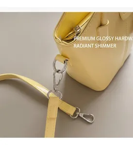 Detail of bright yellow bucket bag with polished silver ring hardware and leather strap