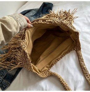 Vue détaillée du dessus d'un grand sac en paille avec des franges et une doublure à poche zippée