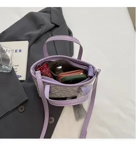 Top view of mini purple bucket bag interior showing phone, wallet, and lipstick storage
