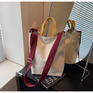 Détail du sac cabas en toile avec sangles contrastées et fermeture à bouton pression