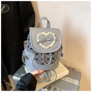 Detail of light blue bow mini backpack with lace heart and silver chain accessory