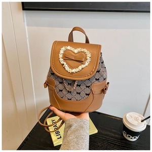 Detail of brown mini backpack with bow lace applique and black-white checkered fabric