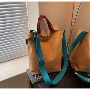 Détail du sac cabas en toile bicolore avec bouton pression en métal et étiquette