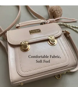 Dettaglio della borsa in pelle rosa chiaro con chiusure a rotazione dorate e cuciture