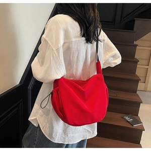 Detailed side view of the red hobo canvas bag featuring black adjustable drawstrings
