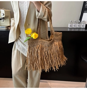 Détail du sac cabas en paille tressée avec de longues franges de style bohème