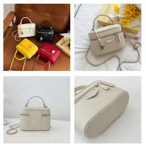 Detailansicht der Box-Tasche aus Leder mit Herzanhänger und Kettenriemen in mehreren Farben