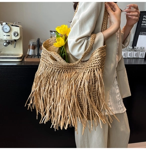 Détail du grand sac cabas en paille fait main avec de longues franges et des pompons