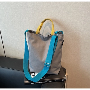 Détail du sac cabas en toile contrastée avec bandoulière réglable et fermoir métallique