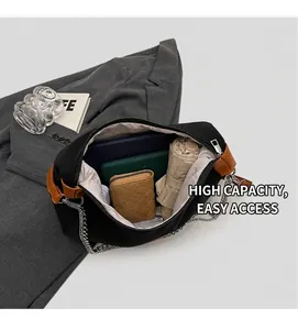 Detail view of large canvas bag interior with brown leather trim and metal chain strap
