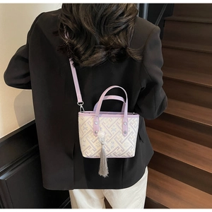Detail of lavender bucket bag with geometric jacquard texture and elegant grey tassel