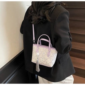 Detail of geometric pattern fabric and purple leather strap on stylish bucket bag