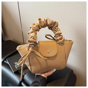 Detail of light beige pleated handle handbag with magnetic flap and smooth PU leather finish