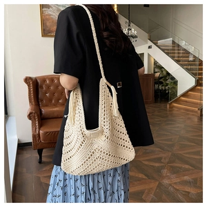 Detail of bohemian cream crochet tote bag featuring intricate weave and long side tassels