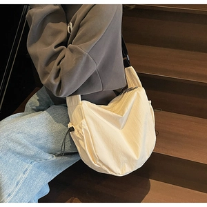 Detail of cream beige large canvas crescent bag with adjustable black shoulder strap