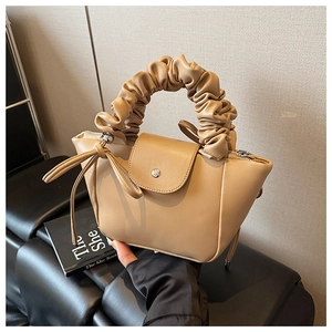 Detailed close-up of khaki mini handbag featuring ruched cloud handle and sleek metal clasp