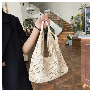 Detail of hand-woven cream tote bag showing intricate crochet patterns and tassel accents