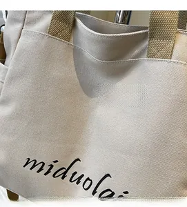 Close-up of minimalist canvas tote bag showing thick fabric texture and logo detail