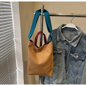 Détail du sac cabas en toile kaki avec anses bordeaux et bandoulière bleue
