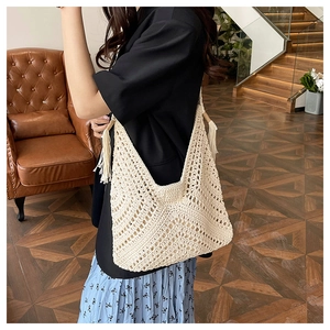 Detail of bohemian cream crochet tote bag with fringe tassels and hollow knit pattern
