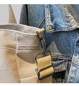 Detailed close-up of durable gunmetal hardware and thick canvas strap on a tote bag