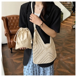 Detail of hand-woven straw tote bag with drawstring lining and decorative tassels