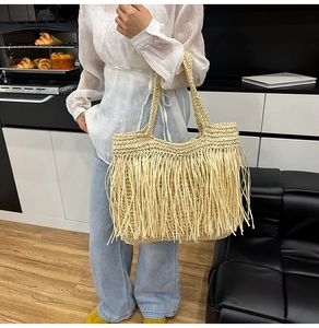 Détail du sac cabas beige tressé avec de longues franges et un style bohème chic