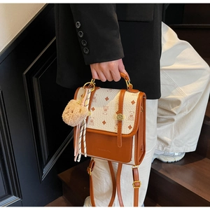 Detail of retro backpack with bear print, metal lock, and plush charm in hand