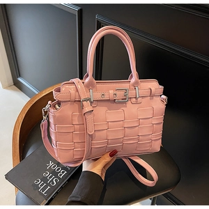 Dettaglio della borsa a secchiello intrecciata rosa con fibbia argento e tracolla