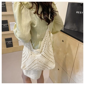 Detailed close-up of handmade off-white crochet hollow texture and decorative side tassel
