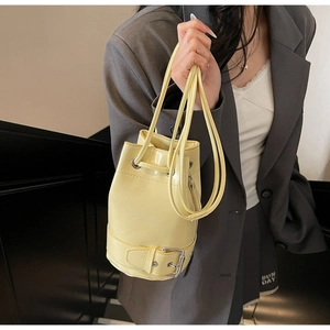 Gros plan détaillé du sac seau crème montrant le cuir PU lisse et la boucle en métal