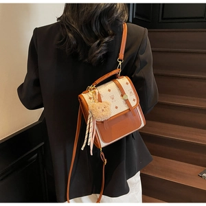 Detail view of a vintage crossbody bag with bear print on a model in a blazer