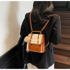 Retro brown and cream leather backpack with bear pattern and pink fur ball detail