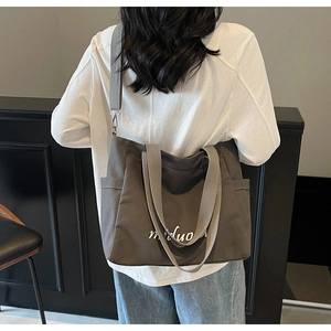 Detail view of large canvas tote bag with adjustable shoulder strap and side pockets