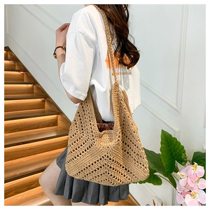 Detail of hand-woven straw tote with crochet pattern and brown drawstring inner lining