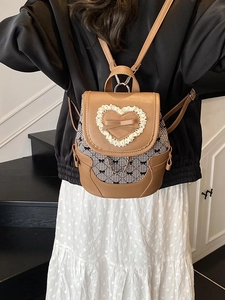 Brown PU leather backpack with lace heart and bow accents on model for student fashion