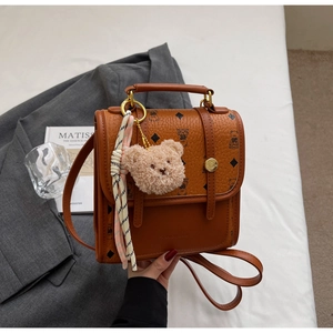 Brown litchi leather bag with bear print, plush charm and decorative silk scarf detail