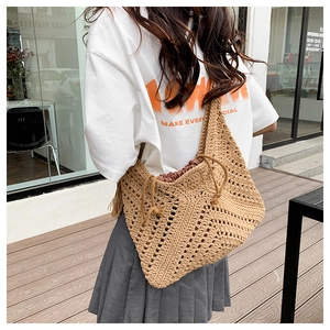 Detail of hand-woven hollow diamond pattern on khaki raffia tote bag with brown lining