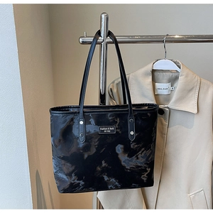 Detail der schwarzen Tote Bag mit Marmormuster, glänzendem Finish und langen Trägern