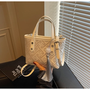 Detailed view of bucket bag featuring geometric patterns, floral prints and grey silk tassels