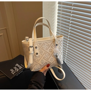 Detailed view of jacquard woven fabric with floral patterns and leather tassels on a mini tote