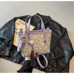 Detail of purple jacquard mini bucket bag featuring floral patterns and silk tassel