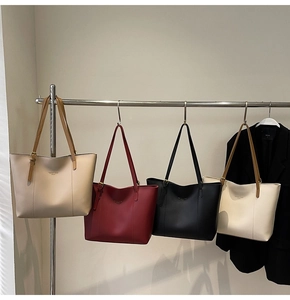 Détail de quatre sacs cabas en similicuir texturé en beige, bordeaux, noir et blanc cassé