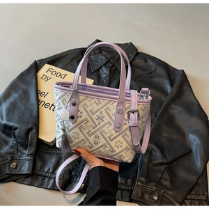 Detail of lavender Chinese style bucket bag with traditional pattern and tassel pendant